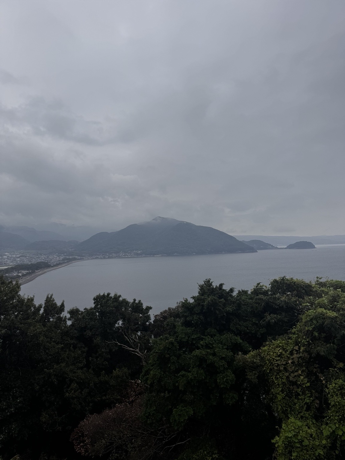 曇り空の海と山